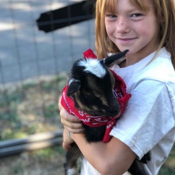 girl holding a baby goat